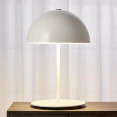 a white lamp sitting on top of a wooden table