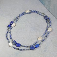 "Necklace Length: 36\" L Material:  4mm round-shaped sodalite, approx. 10x05mm lapis lazuli, freshwater cultured coin pearl, silver-tone spacer beads, 4mm faceted crystals in blue color, and blue thread. Clasp:  stainless steel gold-tone lobster claw clasp and jump ring Workmanship:  each bead is hand-beaded and knotted. https://www.etsy.com/shop/MYGEMSROCK" Sapphire Beaded Necklaces With Natural Lapis Lazuli Stones, Blue Labradorite Gemstone Bead Necklaces, Blue Kyanite Gemstone Bead Necklaces, Blue Labradorite Gemstone Beads Necklace, Blue Kyanite Gemstone Beaded Necklace, Blue Lapis Lazuli Beaded Gemstone Necklaces, Blue Gemstone Necklace In Labradorite, Blue Lapis Lazuli Beaded Gemstone Necklace, Sodalite Gemstone Beads Necklaces