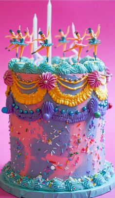 a birthday cake decorated with icing and sprinkles on a pink background