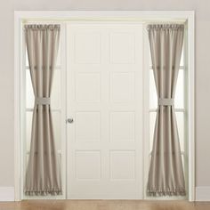 an open door with curtains hanging on the side