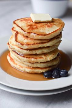 stack of pancakes with butter and blueberries on plate