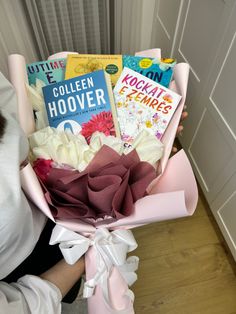 a woman holding a bouquet of books in her hands