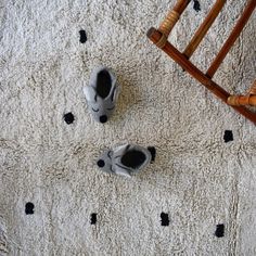 two pairs of baby shoes sitting on top of a white rug