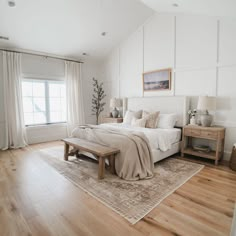 a bedroom with white walls and wood floors