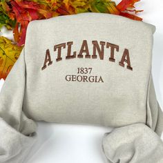 Atlanta Georgia Embroidered Sweatshirt Message me for other cities! Or add your city at the personalization for custom order  -Embroidered Sweatshirt   - Unisex Sweatshirt -Jerzees brand *(Gildan or Port & Co brands may be used to fulfill any back orders that may occur) - Design is 6.8in wide for all  sweatshirt sizes  please message me for any questions. Thank you! Luxury Hoodie With Embroidered Logo For Fall, Luxury Casual Sweatshirt With Embroidered Logo, Luxury Winter Sweatshirt With Embroidered Logo, Luxury Athleisure Sweatshirt With Embroidered Logo, Luxury Embroidered Long Sleeve Sweatshirt, Affordable Sweatshirt With Embroidered Logo For Campus, Affordable Embroidered Logo Sweatshirt For Winter, Cheap Crew Neck Sweatshirt With Embroidered Logo, Luxury Urban Sweatshirt With Embroidered Logo