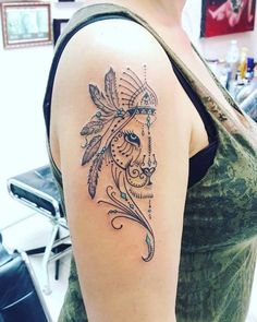 a woman's arm with a tattoo on it that has a horse head and feathers