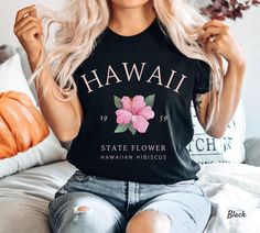 Hawaii Shirt, Hawaiian Tee, Tropical Pink Flower, Soft and Comfortable T-shirt, Unisex Visit our store for more https://www.etsy.com/shop/LittleSwanCrafts This Bella Canvas unisex jersey short-sleeve tee fits like a well-loved favorite.  Super soft cotton, high-quality fabric, and quality print.  - 100% Airlume combed and ringspun cotton (Only heather colors are 52% cotton, 48% polyester - Athletic Heather is 90%    cotton, 10% polyester) - Light fabric - 4.2 oz/yd² (142 g/m²) - Retail fit - Eco Barcelona T Shirt, Florida Shirt, Los Angeles Shirt, National Park Shirt, Family Vacation Shirts, Hawaii Shirt, Vacation Shirts, Travel Outfit, Cool Shirts