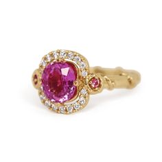 This unique Rose Vine creation features a halo of diamonds and pink sapphires nestled in a cluster of intertwined rose vines, complemented by a glittering pink sapphire centerpiece. Adorned with delicate thorny stems, the elegant band encircles a ring of unrivaled sophistication. About this ring: 14k yellow gold with a polished finish About center gem: 2.03ct Round/Oval, Vibrant light purplish pink, Eye clean About sapphires: with a Mohs hardness of 9, this birthstone of September represents the Pink Cluster Ruby Ring With Diamond, Pink Diamond Cluster Ruby Ring, Elegant Pink Ruby Ring With Halo, Elegant Pink Cluster Ruby Ring, Pink Ruby Ring With Halo Design, Pink Ruby Cluster Ring With Center Stone, Pink Sapphire Diamond Ring, 45th Wedding Anniversary, Rose Vine