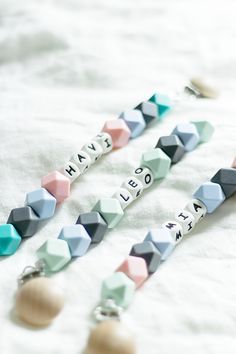 some beads that are laying on top of a tablecloth with words written in them