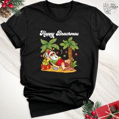 Embrace the magic of the season with our 'Happy Beachmas Holiday Santa Claus Christmas Shirt'. Transport yourself to a tropical Christmas paradise with this vibrant Hawaiian-inspired design. This shirt isn't just a garment; it's a celebration of the festive spirit against the backdrop of sun-kissed beaches and swaying palm trees. Our unique blend of holiday cheer and beach vibes is perfectly embodied in this Hawaiian Christmas Santa Shirt. Whether you're planning a Christmas getaway or simply lo Christmas Palm Tree, Hawaii Christmas, Surfing Santa, Christmas Beach, Hawaiian Christmas, Xmas Tees, Christmas Party Shirts, Beach Tee, Mele Kalikimaka