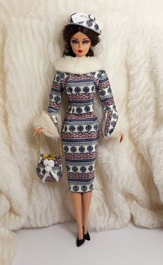 a doll dressed in a blue and white dress with fur collar, hat and purse