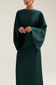 Indulge in luxury with the Batool Satin Maxi Dress. Its loose wide sleeves and lustrous satin fabric exude elegance, while the adjustable tie waist flatters your figure. Versatile design makes it perfect for Eid and beyond. Elevate your style with this exclusive piece. Model is 5'7 wearing size XS/58" Long Sleeve Split Dress, Modest Dresses Wedding Guest, Wedding Guest Dress Muslim, Casual Modest Dresses, Emerald Green Maxi Dress, White Dress Formal, Nikkah Dress, Emerald Green Dresses, Dress Muslim