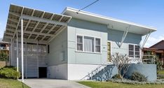 a two story house with a covered front porch and attached walkway leading up to the garage