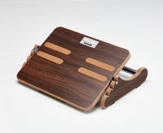 a wooden cutting board with two knives in it and a knife holder on the side