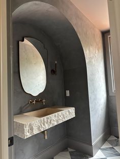 a bathroom with a sink, mirror and tiled floor