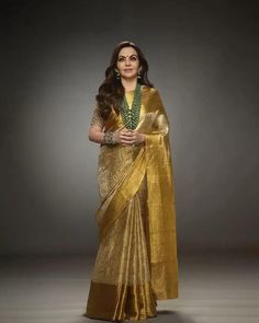 The image you've uploaded shows a person wearing a golden tissue silk saree with intricate work, accessorized with green beaded jewelry and gold bracelets. The saree is elegant and has a rich, traditional design. If you are looking for a specific description or need assistance with something related to this image, feel free to let me know! Nita Ambani, Golden Saree, Tissue Silk Saree, Saree Wearing Styles, Fashionable Saree Blouse Designs, Fancy Sarees Party Wear, Saree Designs Party Wear, Saree Blouse Designs Latest, Saree Trends