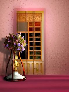 a vase filled with purple flowers sitting on top of a table next to a window