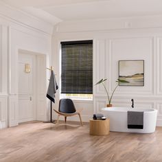 a bathroom with white walls and wood flooring next to a bathtub in the corner