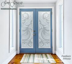 a blue front door with two glass panels and a rug on the floor next to it