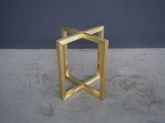 a gold sculpture sitting on top of a cement floor next to a blue wall in an empty room