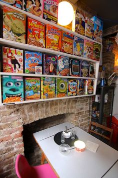 there are many children's books on the shelves above the fireplace in this restaurant