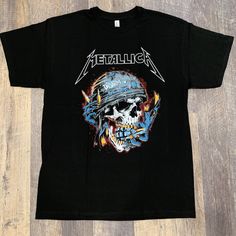 a black shirt with an image of a skull wearing a helmet and flames on it