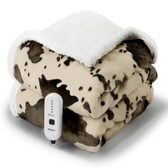 a blanket that is sitting on top of a white surface with a remote control in front of it