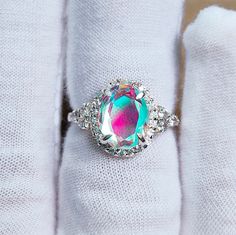 Main Stone : Mystic Opal Stone Size : 10x8 mm Stone Shape : Oval Stone color : Multi color Multi fire Metal : 925 Sterling Silver Plating : Silver / Gold / Rose Gold Side Stone : cz Setting type : Prong setting Occasion : Wedding ,Party, Anniversary, Valentine's Day, Daily Style : Classic Rings Type :Halo ring, Wedding Bands Item Type : Ring If You Have Any Questions, Please Feel Free Contact Us through Etsy Message Service If you want to make jewelry of some other design or other types please c Multicolor Oval Halo Setting Jewelry, Oval Multicolor Jewelry With Halo Setting, Multicolor Oval Jewelry With Halo Setting, Elegant Oval Iridescent Opal Ring, Iridescent Moonstone Gemstone Ring, Silver Opal Ring With Prong Setting, Silver Opal Crystal Ring Fine Jewelry, Dazzling Oval Topaz Ring, Elegant Multicolor Oval Topaz Ring