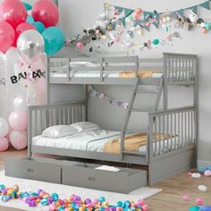 a bunk bed with drawers underneath it and balloons in the background