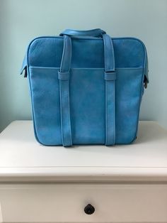 "Vintage Blue Vinyl \"Samsonite\" Carry On Luggage ~  1970's / 80's Baggage Double strap open top zippers with lock snap 2 Large exterior pockets with one that zips  Light blue vinyl lined interior with one pocket zips 4 Stainless steel feet ,roomy interior  Length -14 1/2\" Height -14 1/2\" Width - 7\" Handle drop - 6 1/2\" Weight -3 Lb 1 oz. View wear at edges,spot stain,wrinkled interior liner, and bottom pipping Sold as is , with lots of travel left in her !" Vintage Rectangular Satchel For On-the-go, Blue Standard Backpack With Luggage Sleeve, Vintage Rectangular Travel Bag For Everyday, Vintage Blue Large Capacity Shoulder Bag, Vintage Tote Satchel For On-the-go, Vintage Large Capacity Briefcase For Everyday Use, Vintage Rectangular Everyday Travel Bag, Retro Bags With Luggage Sleeve For Daily Use, Vintage Style Standard Backpack For On-the-go