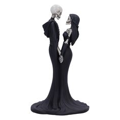 a skeleton figurine holding the hand of a woman in a black dress with her head down