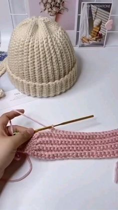 someone is knitting a hat on the table