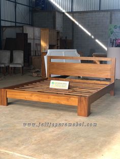 a wooden bed frame sitting inside of a warehouse