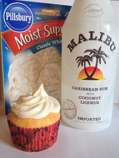 a bottle of milk next to a cupcake with whipped cream on it and a bag of cookies