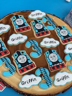 cookies decorated like thomas the train are on a wooden platter