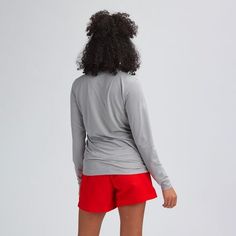 the back view of a woman wearing red shorts and a grey shirt with long sleeves