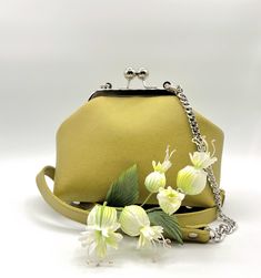 Small Leather Handbag in a Kiss Lock metal frame and with a decorative chain is a fashionable  must have in Your Collection. The combination Green-Yellow color Leather and Leather strap with decorative chain makes it Unique. This Handbag is one of a kind and great for Everyday use. Beautiful Cotton lining and two Pockets inside. Perfect for your cell phone, wallet, makeup and keys. Ready to Ship. 100% Handmade. BAG MEASUREMENTS Height: 5,5" Width: 7" bottom Depth: 4" Strap Drop: 23" NOT adjustable, removable Silver Metal Frame with screws and Ball clasp 5,7" Real colors may slightly differ. Made with love in my home Workshop. I love this bag! The Price of this Leather bag is Without Flowers. You can find more of my Handmade Bags here https://www.etsy.com/shop/FlowDream?ref=simple-shop-head Gift Satchel Evening Bag With Chain Strap, Chain Strap Satchel Evening Bag Gift, Evening Satchel Bag With Chain Strap As A Gift, Yellow Box Bag With Detachable Handle For Evening, Gift Shoulder Bag With Silver-tone Hardware, Silver-tone Hardware Shoulder Bag As Gift, Elegant Green Pouch Satchel, Yellow Evening Shoulder Box Bag, Yellow Shoulder Box Bag For Evening