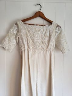 a white dress hanging on a wooden hanger