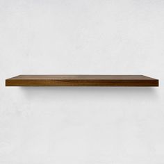 a wooden shelf on the wall with no one around it or in front of it