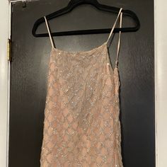 a dress hanging on a hanger in front of a door with a black background