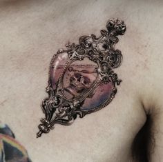 a man with a tattoo on his chest has a skull in the middle of it