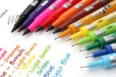 many different colored pens are lined up on top of a sheet of paper with writing