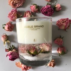 a candle with flowers around it on a table