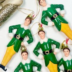 six green and yellow christmas ornament hanging from a string on a white surface