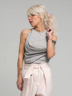 Versatile heather grey tank top, a perfect blend of comfort and style. This essential piece is crafted from a soft mix of cotton and polyester, ensuring breathability and ease of care. Its relaxed fit and neutral color make it a staple for any wardrobe. Pair it with trousers for a smart-casual look or layer it for a laid-back vibe. FEATURES:Sleeveless with a comfortable, non-restrictive neckline, A foundational piece that pairs well with any outfit, Relaxed and flattering for all-day comfort100% Handmade. SIZE & FIT: Fit: A relaxed fit with room to moveModel is wearing size Small or S/M View our SIZE CHART before ordering MATERIALS & CARE: Content: 50% Cotton, 40% Polyester, 10% Elastane Care: Machine wash on cold (30ºC) with a mild detergent. SHIPPING: Made to order, processing time is 15 Stretch Gray Cotton Tank Top, Gray Stretch Cotton Tank Top, Gray Athleisure Top For Everyday, Gray Casual Tank Top For Everyday, Casual Gray Tank Top For Everyday, Chic Gray Tank Top For Summer, Chic Gray Summer Tank Top, Gray Tank Top For Layering, Casual Gray Tank Muscle Tee