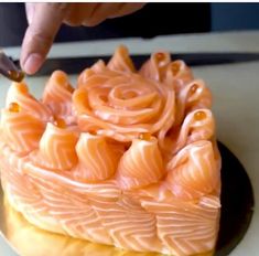 someone is cutting into a cake with orange icing