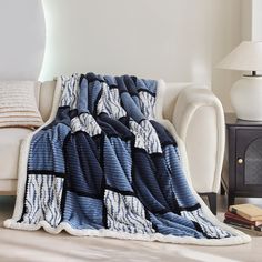 a blue and white blanket sitting on top of a couch