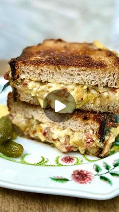 a grilled cheese sandwich on a plate with pickles and jalapenos