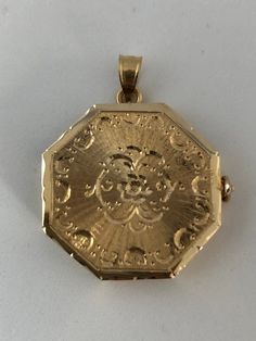 This hand-made octagon locket is as sentimental and unique as it gets. It is made of 14 karat gold. It is both beautiful and functional. It uniquely holds 4 photos which insert into the top of the locket's 3 frames. The entire locket is handmade, from it's precision hinge to the handmade clasp. It is hard to match the workmanship of this locket and it's engraving. It is truly heirloom quality. It was crafted by a very talented jeweler in the NYC jewelry district between 1970 - 1980. Lockets are Gold Engraved Octagon Jewelry, Vintage Gold Octagon Jewelry, Vintage Octagon Gold Jewelry, Vintage Octagon Jewelry Gift, Antique Octagon Jewelry Gift, Antique Octagon Shaped Jewelry For Gifts, 14k Yellow Gold Octagon Jewelry, Nyc Jewelry, 4 Photos