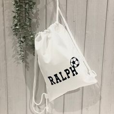 a drawstring bag with the word rapp on it next to a plant